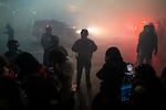 FILE - Cars exit the U.S. Immigrations and Customs driveway as federal officers stand by after deploying tear gas, flash-bangs and pepper balls on nonviolent protesters outside the facility to clear the driveway in Portland, Ore., Oct. 18, 2025. 