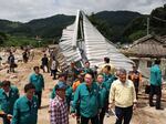 South Korean President Yoon Suk Yeol, bottom center, looks around a flood damaged area in Yecheon, South Korea, Monday, July 17, 2023.