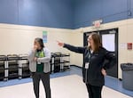 Yaquina View Elementary School principal Kristin Takano Becker, left, and Lincoln County School District Communications Coordinator Kristin Bigler inside the current Yaquina View gym. The gym currently serves as a cafeteria and gym for students at the school.