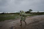 A man walks in the rain before the arrival of Hurricane Melissa in Canizo, a village in Santiago de Cuba, Tuesday, Oct. 28, 2025.