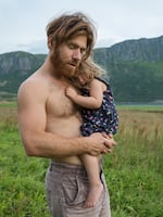 Parsa holds his daughter Arda (wearing her butterfly dress) at Polarhagen Farm in Norway.