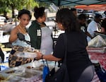 Volunteers and a culinary student group serve free barbecue at the Juneteenth celebration.
