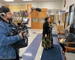 In this image from May 2024, cinematographer LaRonn Katchia films as Abby Hall speaks with a Klamath Tribes elder at the Klamath Tribes offices in Chiloquin, Oregon.