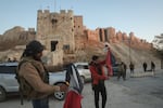 Syrian opposition fighters burn government Syrian flags for the cameras next to Aleppo's old city on Saturday.