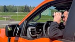 Nick Atwell uses binoculars out of bright orange truck