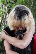 Carrie finds comfort in her dog Kona, as well as her five children in town who bring water for the couple.