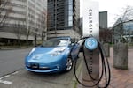 FILE - A car is parked by an electric charging station in downtown Portland, Ore., March 31, 2011.