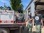 Jalisco Miles and Farrell Hayes check on a fire engine pump at the Nez Perce Tribe Forestry & Fire Management Division fire station in Lapwai, Idaho on June 12, 2024.
