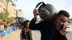 Men carry empty canisters to be filled with cooking gas from a tanker that entered the Palestinian enclave via the Rafah crossing with Egypt, on Saturday.