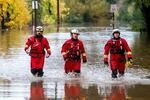 Firefighters walk through floodwaters while responding to a rescue call in unincorporated Sonoma County, Calif., on Friday, Nov. 22, 2024.