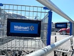 Shopping carts sit in the parking lot of a Walmart store in Rohnert Park, Calif., on Aug. 4. In a letter to shareholders, Walmart's CEO said its customers are spending less on clothing and other merchandise because food prices have continued to rise.