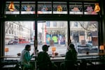 Customers sit at a counter in GeekEasy Anime Cafe overlooking NW Third Avenue, Portland, Ore., Feb. 6, 2025. Co-founders A.T. Nguyen and Tommy Ly say they grew up coming to the area, which they knew as Chinatown, and want to bring business back to the neighborhood. 