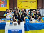 Evghenia Sincariuc, (third from right, front row) stands with members of the nonprofit organization Ukraine Care, in front of the KEEN Garage, July 7, 2022, as part of the "First Thursday in the Pearl District" event.  Ukraine Care is a nonprofit organization dedicated to providing fresh bread for people in Ukraine.