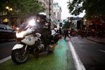 Police officers park at major intersections to redirect traffic and ensure the safety of the protestors and drivers on the road.