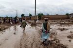 People are seen near to their damaged homes after heavy flooding in Baghlan province in northern Afghanistan on Saturday.