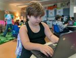 Aubrey Stone, 8, focuses on computer work during class at Fern Hill Elementary School in Forest Grove, Ore., Nov. 9, 2023.