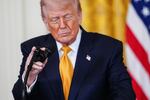 President Donald Trump adjusts his microphone while speaking during an event for military mothers in the East Room of the White House, Wednesday, May 6, 2026, in Washington.