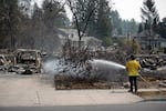 A firefighter puts out a hot spot to prevent new blazes on August 6, 2026 in Spokane, Wash.