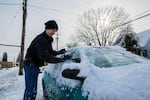 David Schor scrapes snow and ice off his car in Southeast Portland, Wednesday, Feb. 21, 2018.