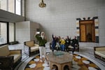 A group of people take a family photo while sitting on a couch in a hall of Syrian President Bashar Assad's presidential palace in Damascus, Syria, Sunday.