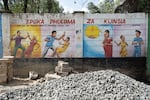 A mural on a wall encourages women and girls to report sexual harassment or assault.