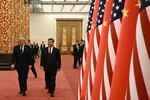 China's President Xi Jinping and President Trump walk past a line of alternating U.S. and Chinese flags. 