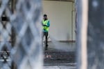 A person pressure-washes the portico of the Mark O. Hatfield federal courthouse in Portland, Ore., July 30, 2020, the morning after law enforcement deployed tear gas to disperse protesters. Environmental specialists know little about the long-term effects of tear gas on plants, water and wildlife.