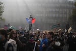 A protester holds a French flag at Republic Square during a demonstration against rising living costs, joining students' grievances, in Paris, Saturday, Oct. 17, 2026.