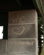 A message scrawled in chalk on the inside of the baseball dugout of Oppenlander Field in West Linn, Ore., on July 22, 2026.