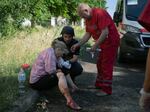 A police officer and paramedic give first aid to a woman wounded by the Russian shelling at a crowded shopping mall in Kremenchuk, central Ukraine, on Monday.