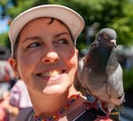 Rebekah Cook, a member of the PDX Pigeon Lovers, and Atlas the Pigeon watch the Portland Pride Parade.
