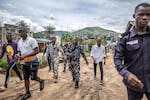 A combined military and police task force, including some in plain clothes, return to their vehicles after arresting a suspected kush dealer in Waterloo, Sierra Leone.