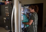 Sethmann loads groceries into her refrigerator after returning home from the evacuation.