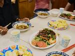 Migrants share a home-cooked communal meal at a group home in Queens, NY