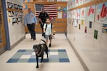 Freetown Elementary School student Ariel Pimentel gets a chance to walk Hunter. Principal Mike Ward, left, keeps an eye on him, while K-9 officer Ct. Paul Douglas follows behind.