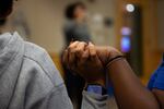 Amiyah McGregory and Danniella Wilson hold hands while Skyler Brown-Evans taslks during an Ujima meeting in Bend, Ore., on Oct. 16, 2024.