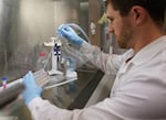 FILE - Research scientist Kevin Potts works on ovarian cancer cells being grown on a plastic plate at UW Medicine's Cancer Vaccine Institute Thursday, May 25, 2023, in Seattle. UW Medicine has faced a cut of almost 20% of its federal funding in the last fiscal year.