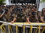 Members of police stand guard in front of the police headquarters during a protest by demonstrators demanding actions against authorities over attacks on protesters and media amid ongoing economic crisis in Colombo on July 11.