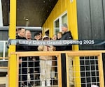 Eleven-year-old fire survivor Parker Crabb cuts the ribbon on the porch of one of the Lazy Days Community modular homes near Blue River, Ore.