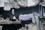 A bed dangles from a building that partially collapsed, Thursday, June 24, 2021, in Surfside, Fla. A wing of a 12-story beachfront condo building collapsed with a roar in a town outside Miami early Thursday, trapping residents in rubble and twisted metal.