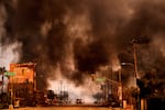 Smoke and flames overwhelm a commercial area during the Eaton fire.