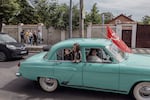 A girl waved out the window of a car during a Victory Day parade in Chișinău, Moldova, May 9. Many from Moldova’s Russian-speaking population remain nostalgic for the days of the former Soviet Union.