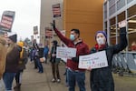 Two leaders of the Oregon Education Association, right, which represents Oregon teachers, joined the crowd outside the Hawthorne Fred Meyer in Southeast Portland, Dec. 17, 2021. A weeklong strike by unionized employees at some Oregon Fred Meyer and QFC stores began at 6 a.m.