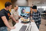 In this photo released by OSU-Cascades, computer science faculty member Patrick Donnelly (second from left) works with juniors Micah Stalberg, Kimberly Markley and Daniel Lau (left to right). The lab is developing a smart compost bin that tracks how much food is tossed inside.