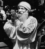 Indian guru Bhagwan Shree Rajneesh greets his followers, or sannyasins, as part of his daily afternoon drive-by in one of his Rolls-Royce at his ashram Rajneeshpuram, Ore., Aug.18, 1984.