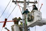 PGE contractors from DJ's Electrical in Portland repair a transformer box on a power pole on Southeast Madison Street near Southeast 17th Avenue in Portland, Feb. 16, 2021.