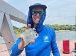 Luke Ovgard pictured with his 1,000th species, the silver moony, Monodactylus argenteus, caught while fishing in Singapore, July 12, 2022.