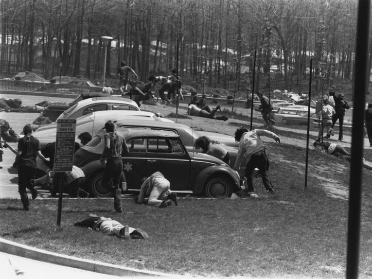 People ducking and running for cover near a parking lot during the shooting at Kent State University on May 4, 1970.