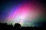 The northern lights flare in the sky over a farmhouse, late Friday, May 10, 2024, in Brunswick, Maine.