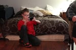 Talin, 10, plays with a smartphone while his parents talk at the Portland Value Inn in March 2018.